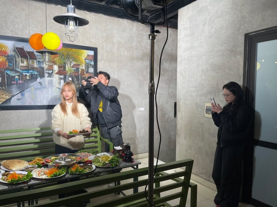 Đội VNTAY quay video giới thiệu mâm món ăn tại nhà hàng, người dẫn cầm đĩa món trước máy quay Đội VNTAY quay video giới thiệu mâm món ăn tại nhà hàng, người dẫn cầm đĩa món trước máy quay