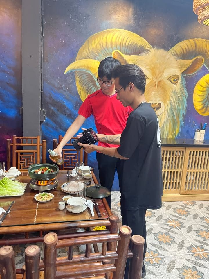 Hai thành viên VNTAY dựng cảnh chụp nồi lẩu trước bức tranh dê vàng Hai thành viên VNTAY dựng cảnh chụp nồi lẩu trước bức tranh dê vàng