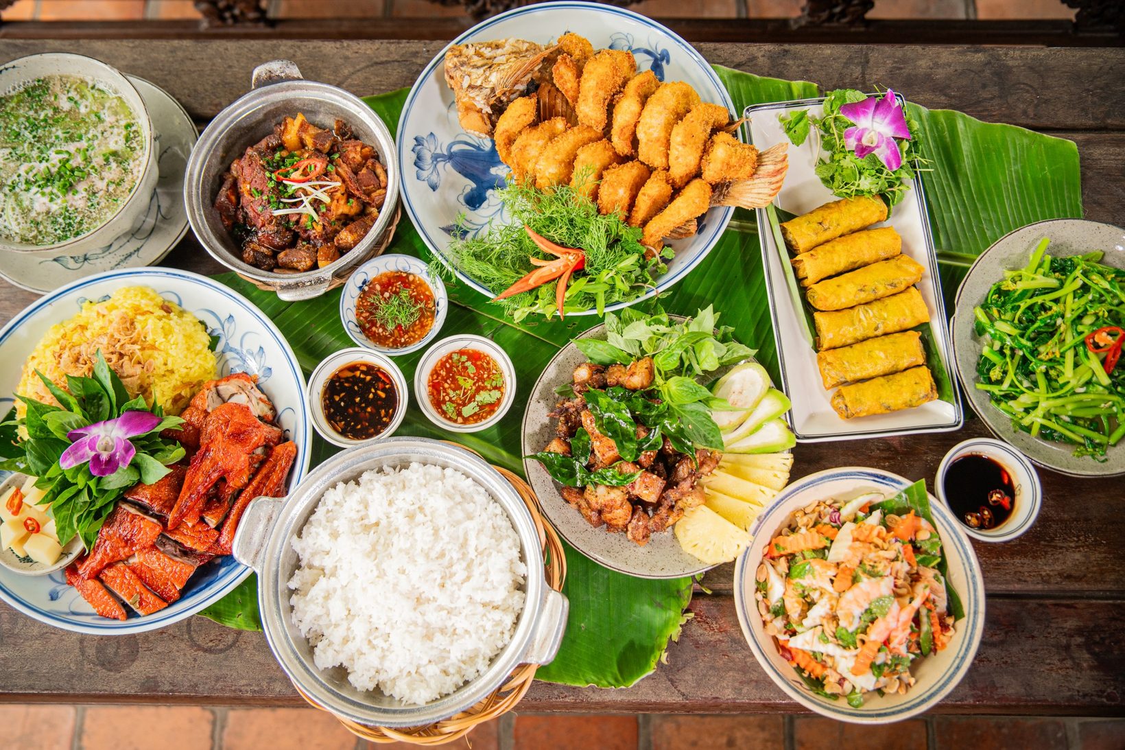Ảnh bìa fanpage VNTAY: mâm cơm Việt với cá chiên giòn, nem rán, thịt kho, rau muống xào bày trên lá chuối